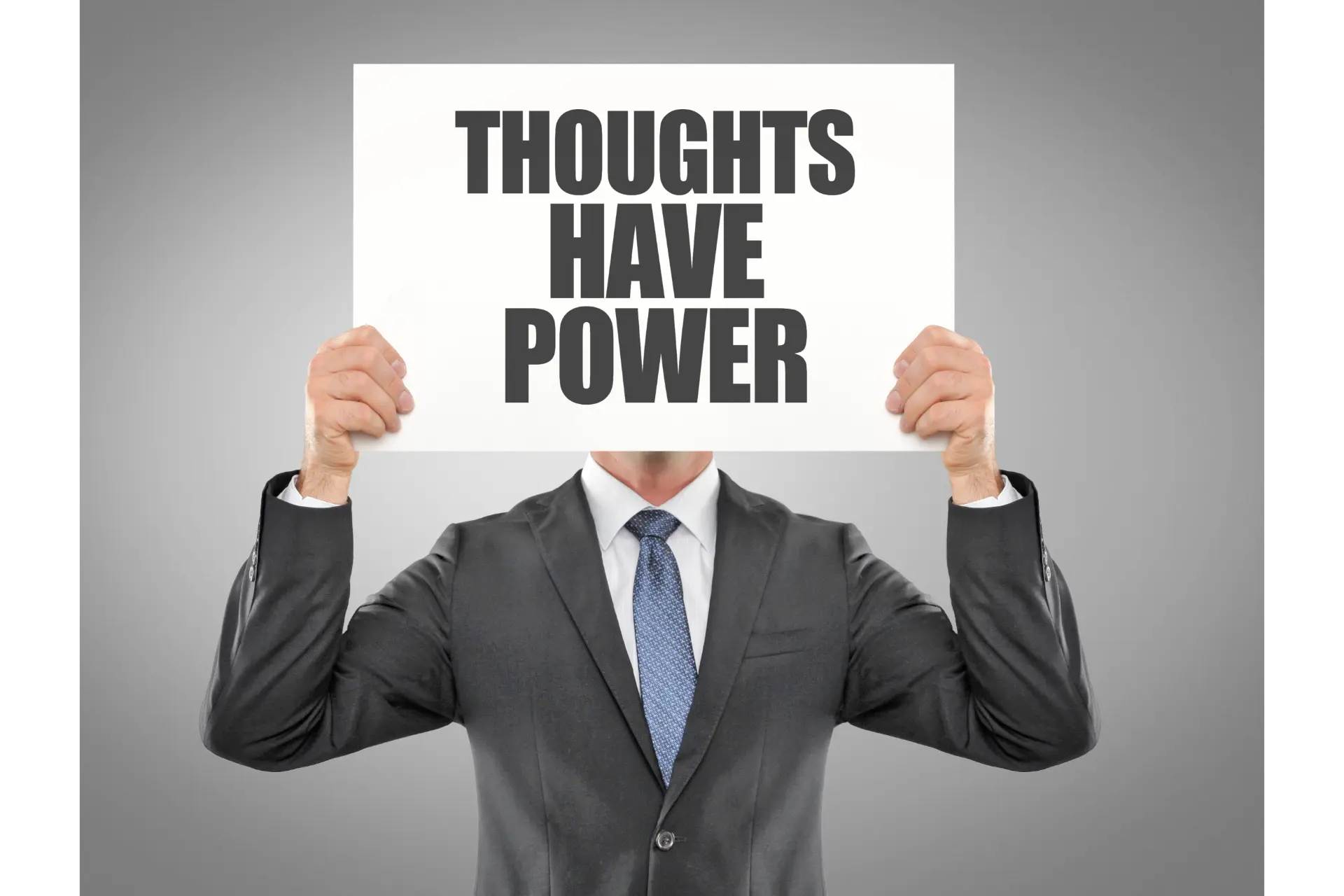 Mann im Anzug der ein Schild hochhaelt mit der Aufschrift: Thoughts have Power